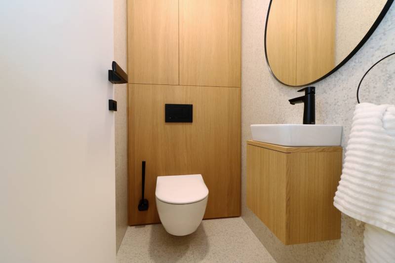WC fa mintázatú padlóval és modern mosdóval egy 4 szobás lakásban.