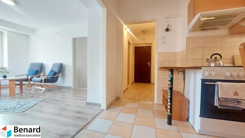 Konyha nappalival, fehér falak, fa mintás padló, 2 szobás lakás.