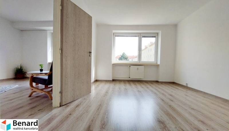 2 szobás lakás belső tere fa dekor padlóval és világos falakkal.