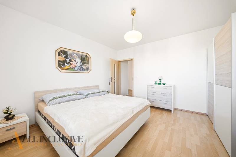 Hálószoba fa dekor padlóval egy családi házban és egy képpel a falon.