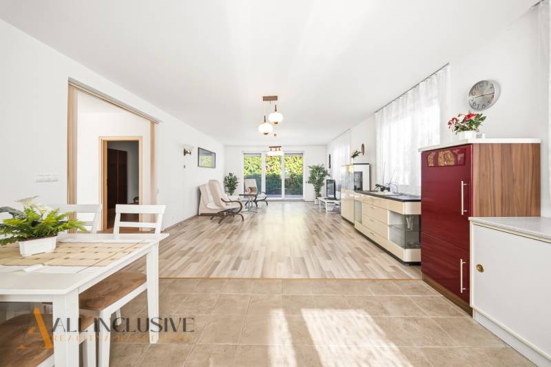 Családi ház belső tere világos nappalival és fa mintázatú padlóval.