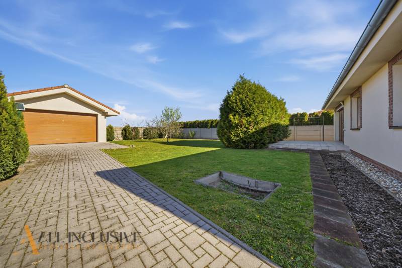 Családi ház Kútnikokban garázzsal, gyepesített udvarral és szilárd burkolatú bejárati úttal.