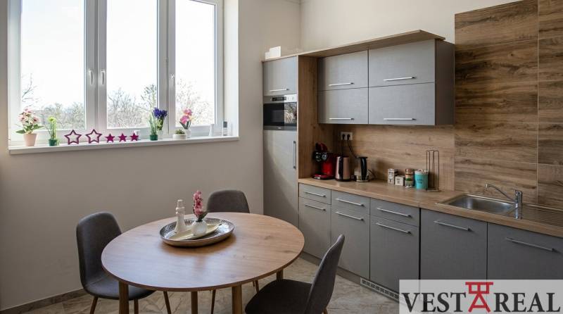 Irodai konyhasarok ablakos, fa dekorációval és étkezőasztallal.