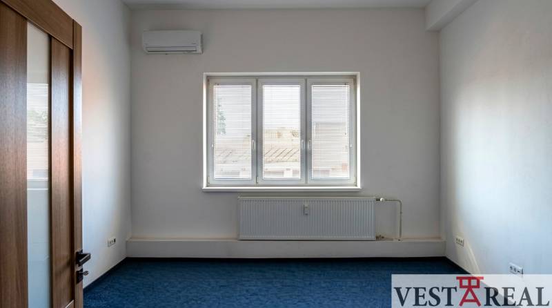 Légkondicionált szoba ablakkal az irodákban, kék szőnyeg, fehér falak.