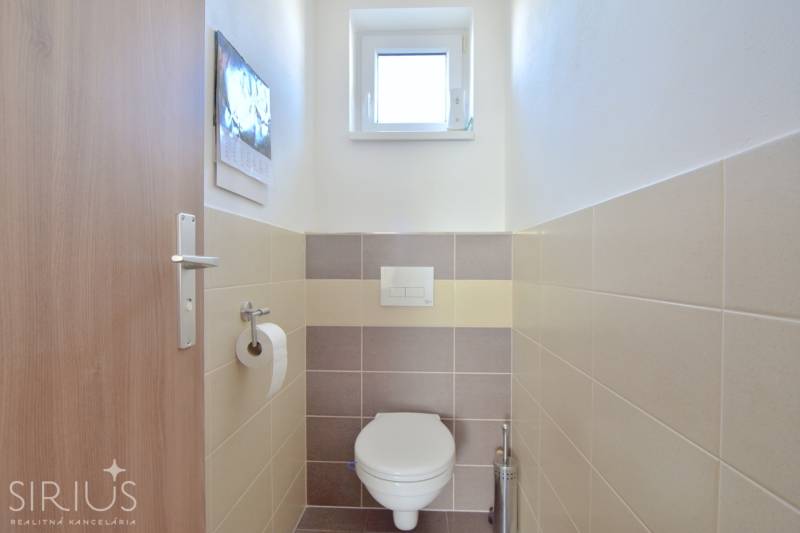 Kis WC ablakkal és csempével egy háromszobás lakásban.