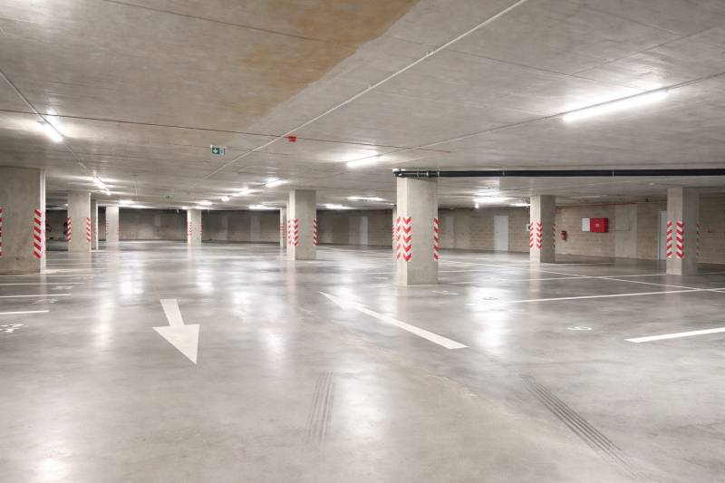 Földalatti parkoló kijelölt helyekkel és oszlopokkal a garázsban.