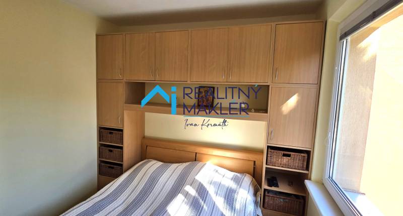 Hálószoba finom falakkal és tárolóhellyel egy háromszobás lakásban.