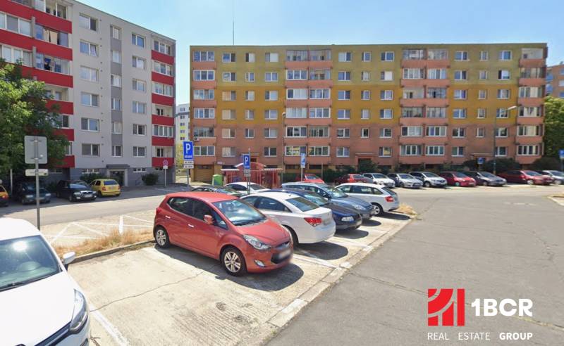 Parkoló a pozsonyi - račai lakóházak előtt színes homlokzatokkal.