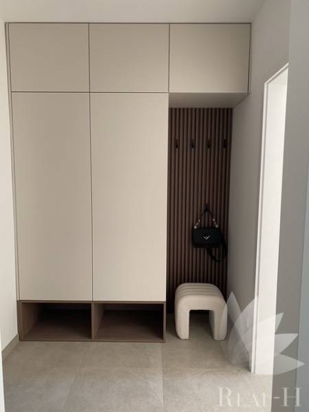 Beépített szekrény egy kétszobás lakásban akasztóval és zsámollyal.