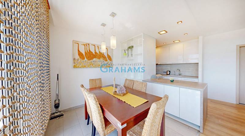 Étkezőhelyiség faasztallal és dekoratív művészettel egy kétszobás lakásban.