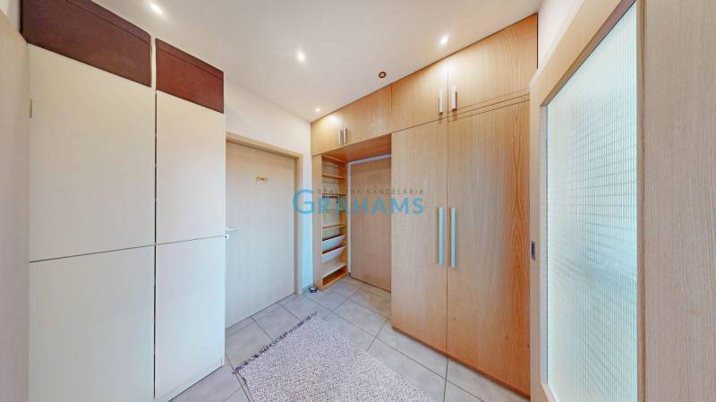 Beépített szekrények és csempézett padló egy kétszobás lakásban világos bútorokkal.