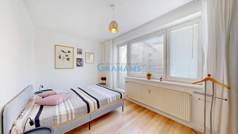 Világos hálószoba egy kétszobás lakásban, dekorációkkal a fehér falon.