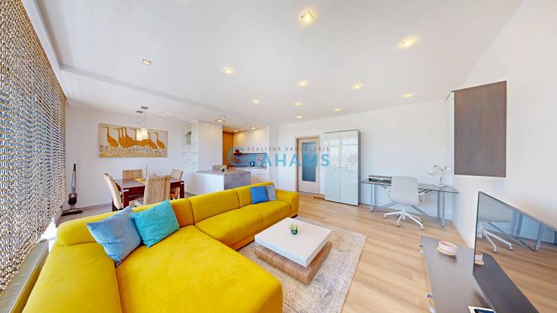 Világos nappali tér élénksárga kanapéval, étkező sarokkal és fa dekorációjú padlóval.