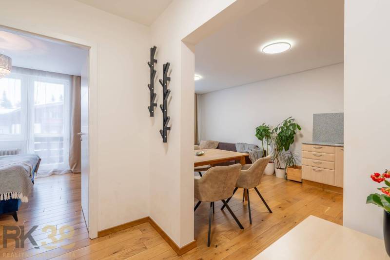 Nyaraló apartman belső tér fa dekor padlóval, étkezővel és hálószobával.