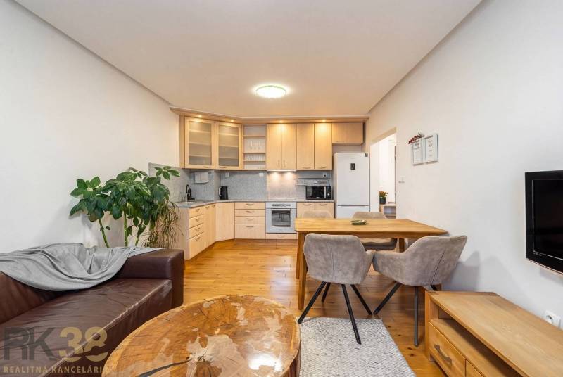 Nappali konyhasarokkal egy üdülő apartmanban, fa dekorációjú padlóval.