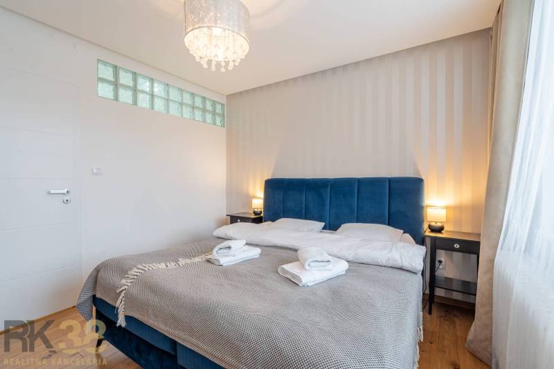 Hálószoba üdülő apartmanban franciaággyal és fa dekorációjú padlóval.