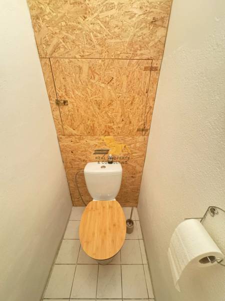 Fa dekorral és OSB lappal ellátott WC egy kétszobás lakásban.