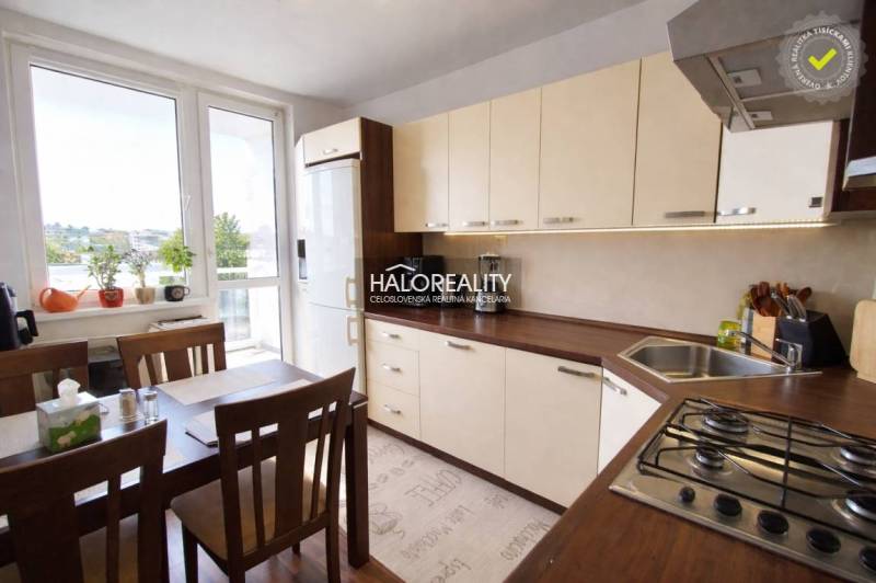 Konyha egy 4 szobás lakásban nagy ablakkal, étkezőasztallal és világos bútorokkal.