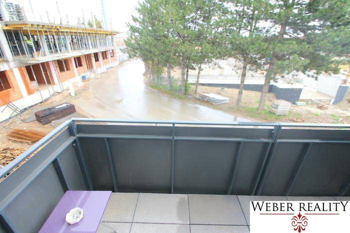 Félkész épületek és fák a Broskyňová utcában Rovinkán, kilátás egy egyszobás lakásból.