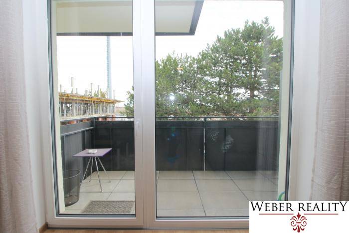 Erkély tolóajtókkal és kilátással a fákra egy egyszobás lakásban a Broskyňová utcában, Rovinkában.