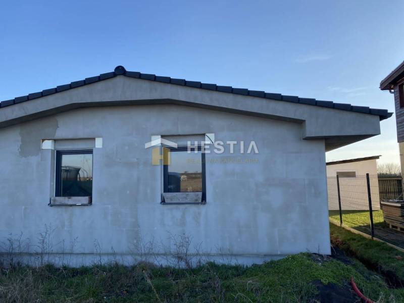 Családi ház Székelyeken befejezetlen homlokzattal, lapos tető, két ablak.