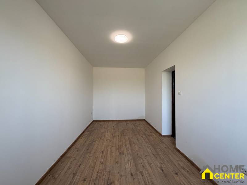 Családi ház fehér falakkal és fa dekorációjú padlóval.