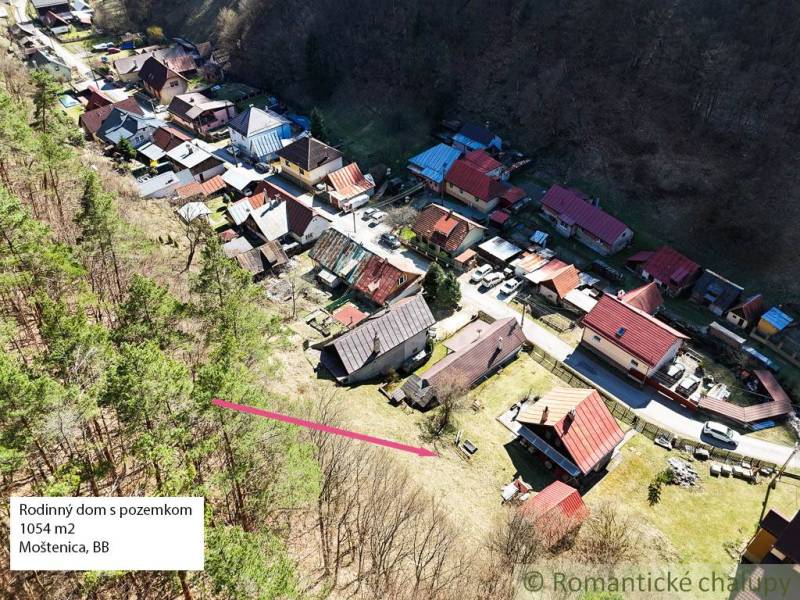 Kilátás a Moštenicában található házakra, amelyek az erdőben és a környező természetben helyezkednek el.