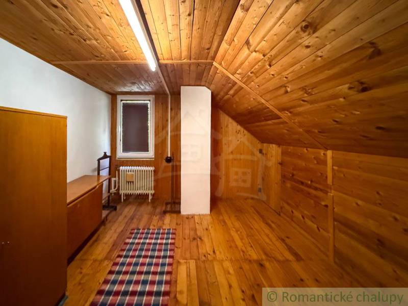 Egy fahatású padlóval és paraszti bútorokkal berendezett házikó belső tere.