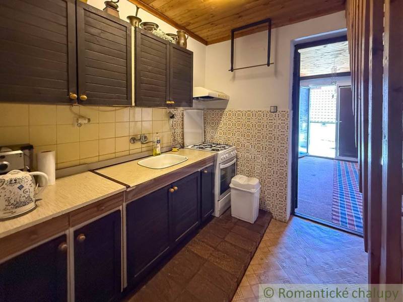 Ház rusztikus konyhával, fa dekorációval és stílusos burkolattal.