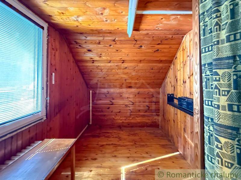 Egy fahatású padlóval és tetőablakkal rendelkező szoba a házikóban.