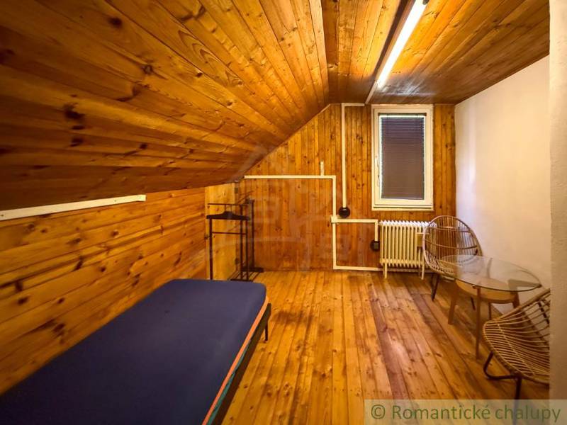 A fahatású padlóval rendelkező házikó belseje, ágy és székek a kényelem érdekében.