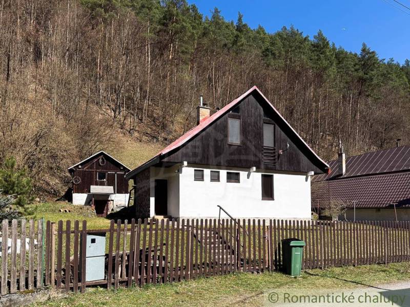 Ház Moštenicában, erdőkkel körülvéve, kerítéssel és szemetes a kertben.