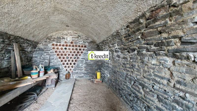 Kőpince a szőlőskertben bor tárolóhellyel és edényeknek polccal.