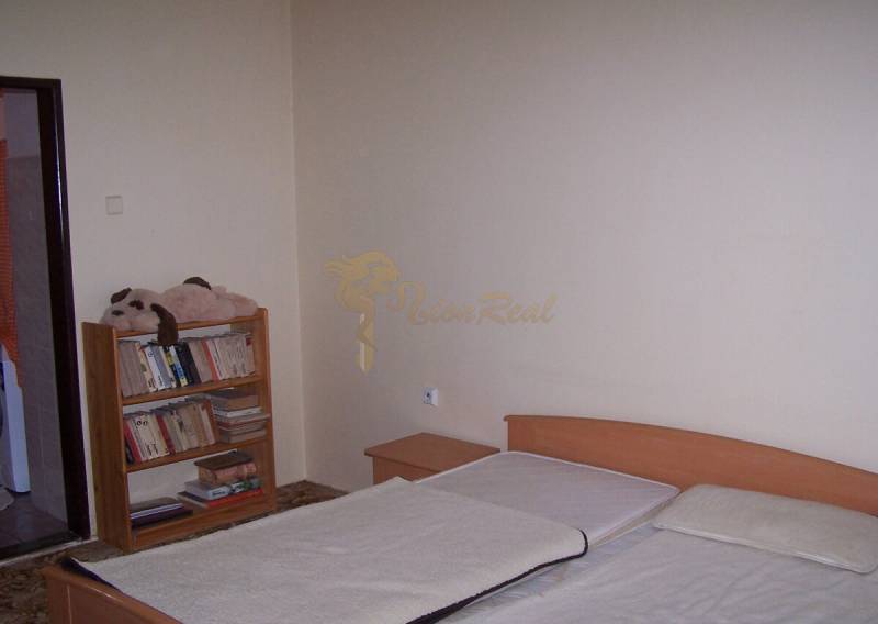 Hálószoba ággyal és könyvespolccal, ideális kétszobás lakáshoz.