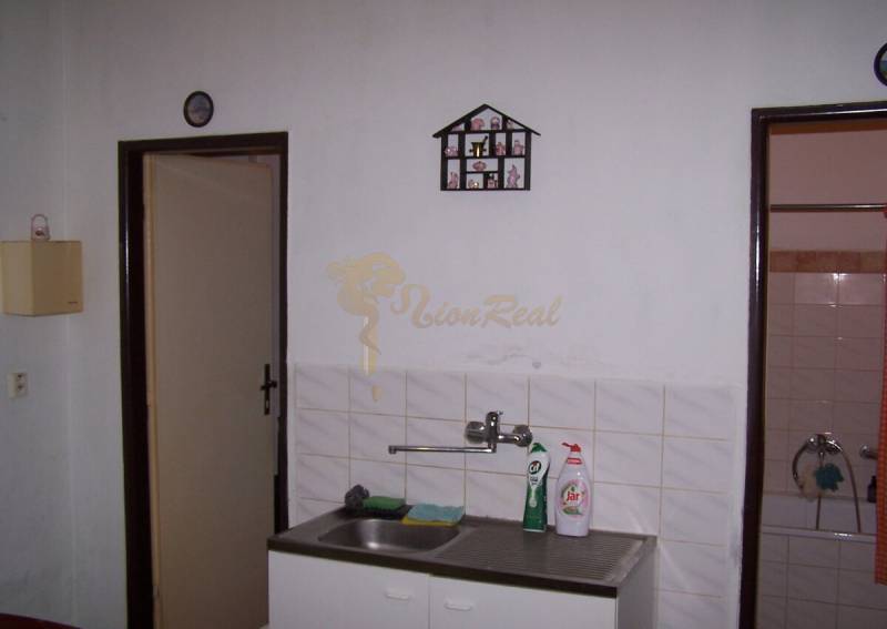 Konyha függő edényszárítóval a mosogató mellett egy kétszobás lakásban.