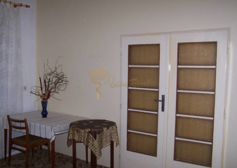 2 szobás lakás belső tere étkezőasztallal és üvegajtókkal.