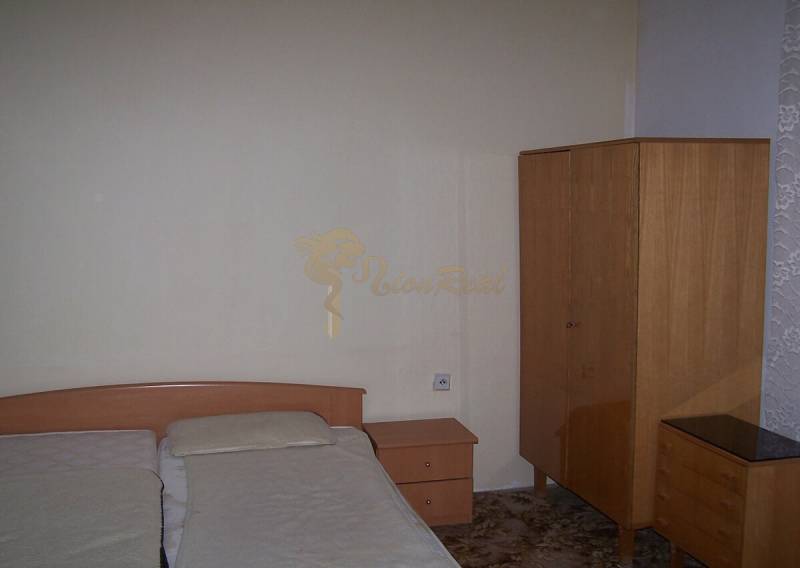 Hálószoba egy kétszobás lakásban egyszerű bútorokkal és franciaággyal.