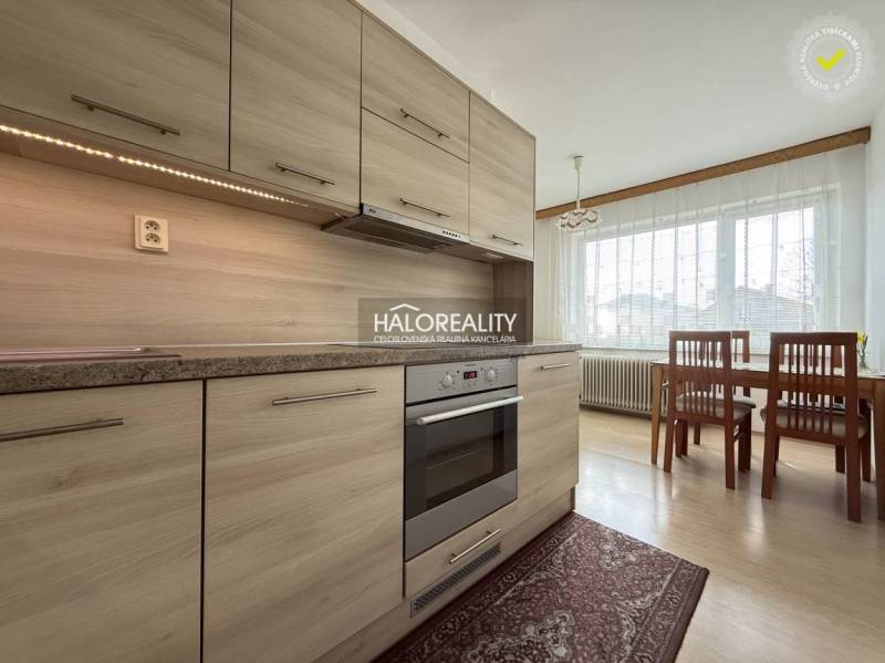 Konyha egy családi házban fa dekorációjú padlóval és étkezőasztallal.