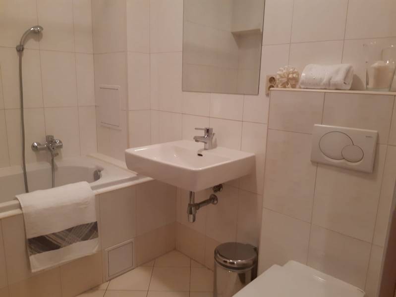 Fürdőszoba egy háromszobás lakásban káddal, mosdóval és WC-vel.