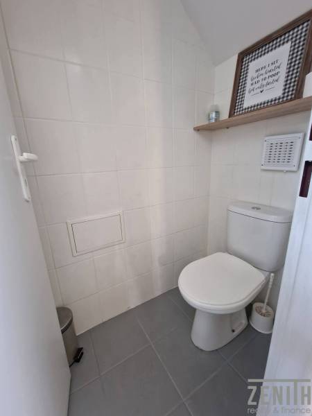 Fehér csempés mosdó dekoratív polccal kereskedelmi helyiségben.