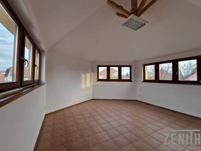 Kereskedelmi helyiségek belső tere csempével és nagy ablakokkal, amelyek elegendő természetes fényt biztosítanak.