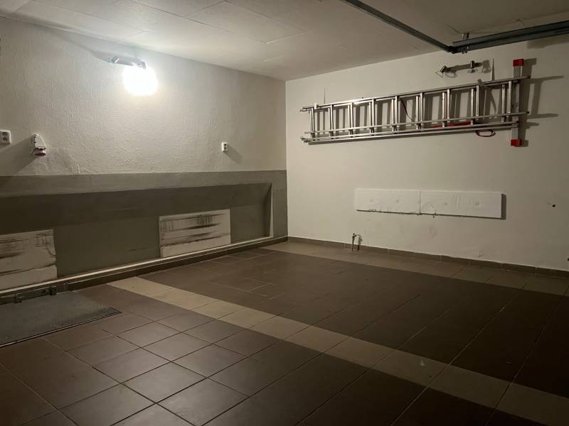 Családi ház garázsa kerámia padlóval és létrával a falon.