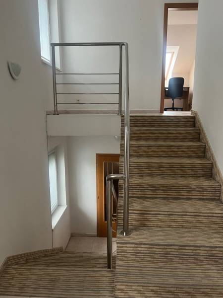 Lépcső korláttal vezet a szobába a családi házban, fehér falak.