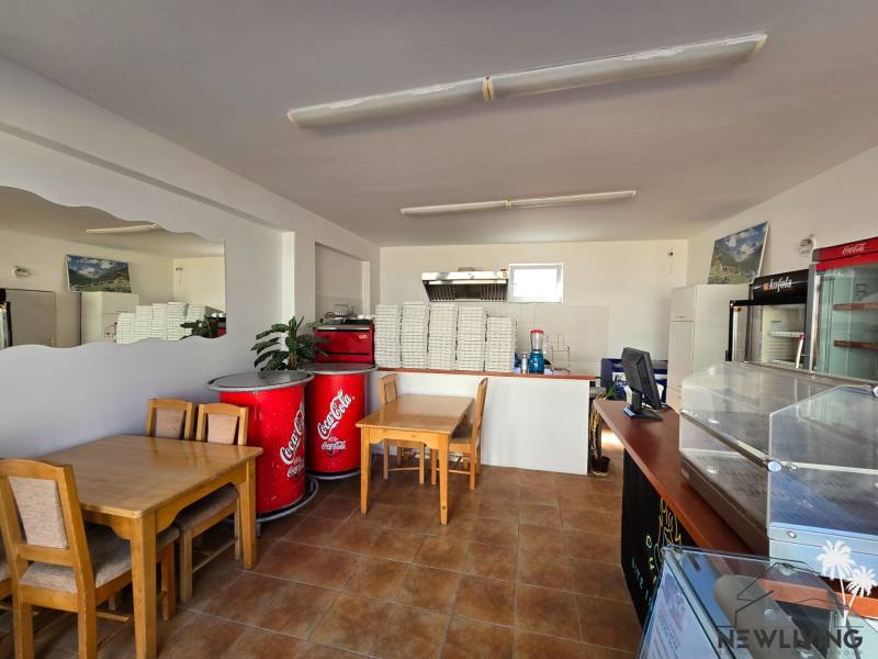 Vendéglátóhelyiség fa dekorációjú padlóval, asztalokkal és hűtőszekrényekkel.