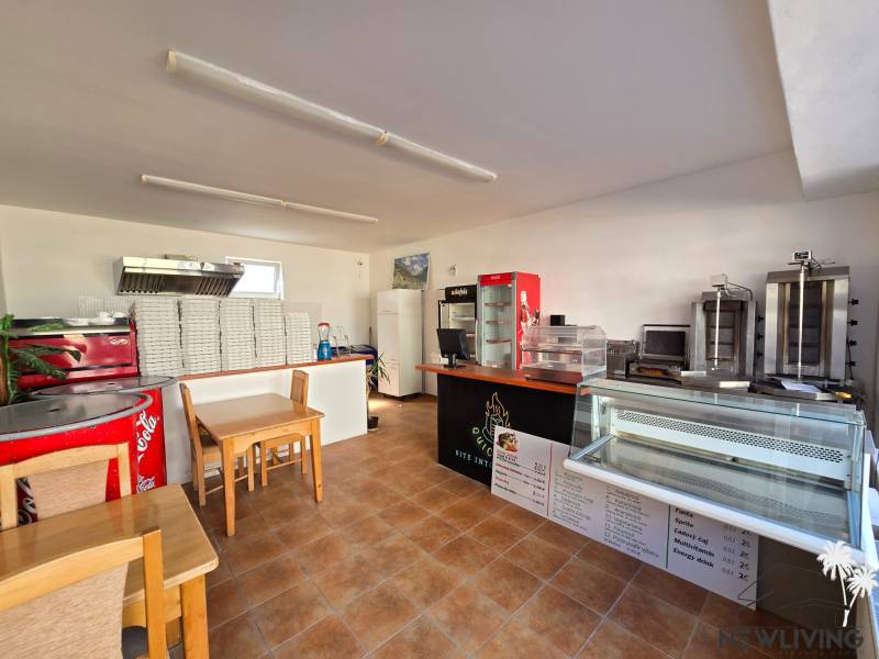 Vendéglátóhely belső tér pulttal, hűtővitrinekkel és pizzásdobozokkal.