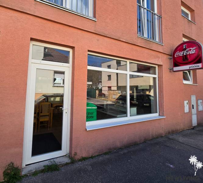 Vendéglátóhelyiségek a Piešťany Mierová utcáján kirakattal és Coca-Cola reklámmal.