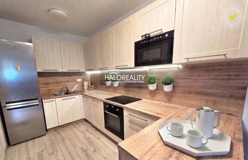 Modern konyha egy kétszobás lakásban fa dekorációval és beépített készülékekkel.