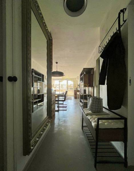 Előszoba nagy tükörrel, fogasokkal és paddal egy háromszobás lakásban.