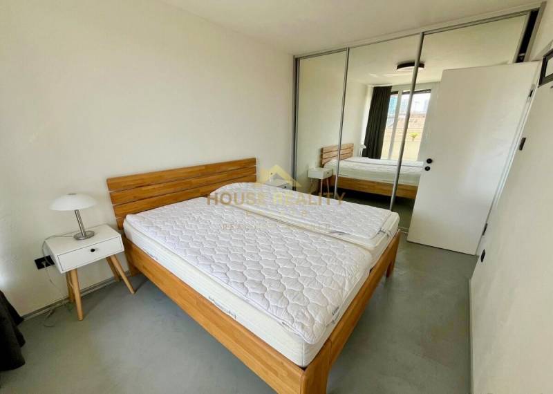 3 szobás lakás ággyal, szekrénnyel, éjjeliszekrénnyel és tükrös ajtókkal.