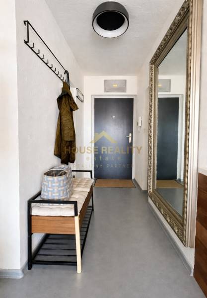 A háromszobás lakás előszobája padkával, fogassal és nagy tükörrel a falon.